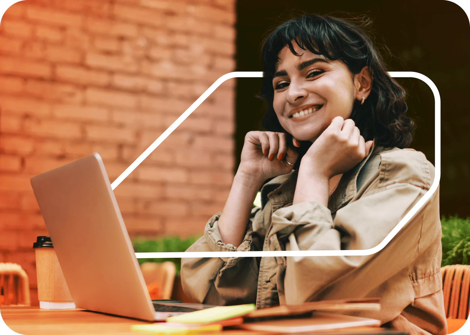 Woman smiling, talking on phone, and writing in notebook